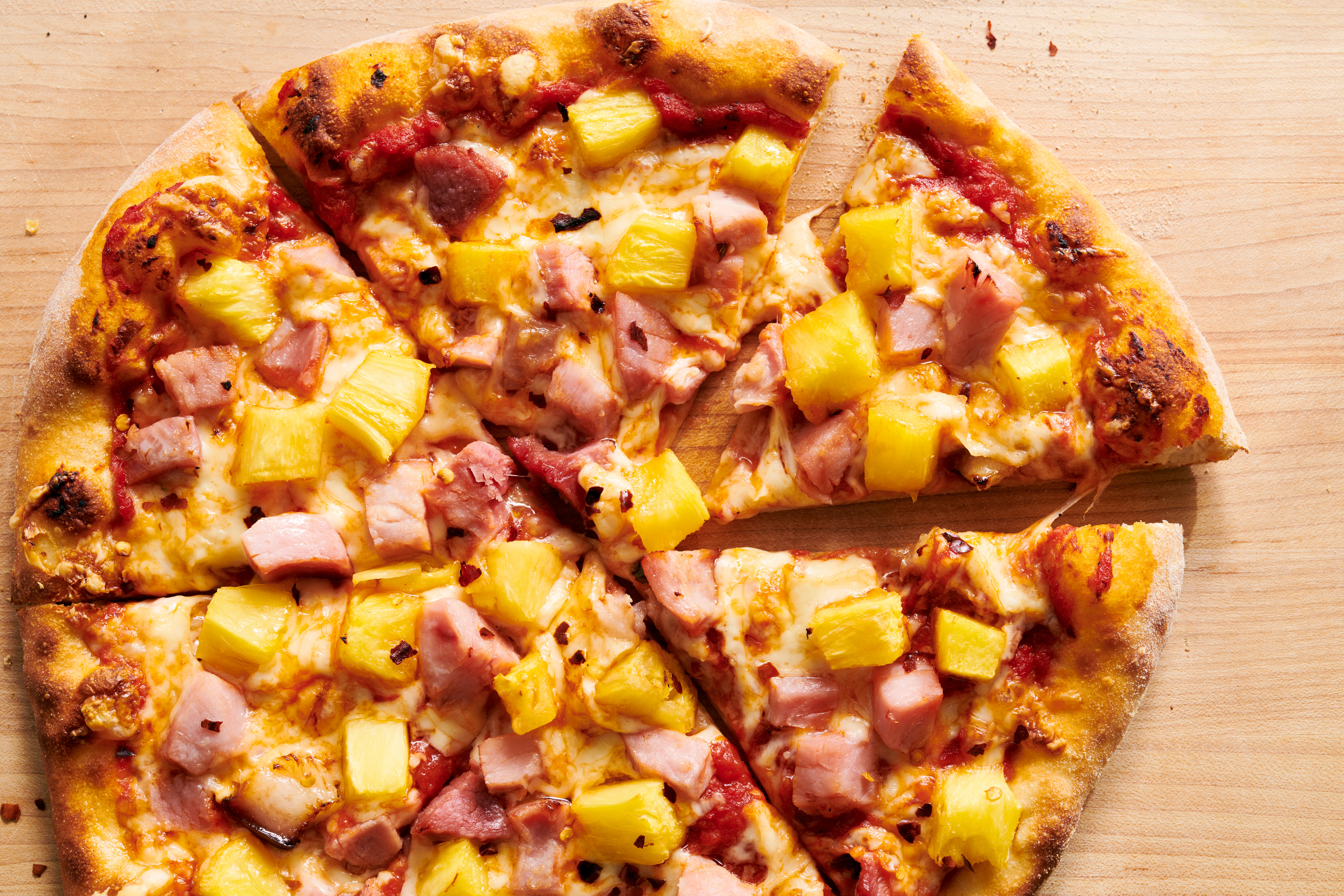 Ham pizza on dark serving board